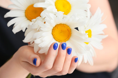 Woman with beautiful manicure and bouquet of chamomile flowers, closeupの写真素材