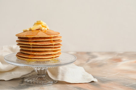 Tasty pancakes with butter and honey on tableの写真素材
