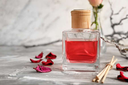 Reed diffuser on table against light background