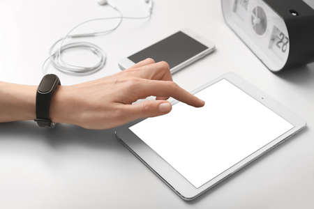 Woman using tablet computer at table, closeup