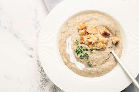 Plate of tasty cream soup on light background