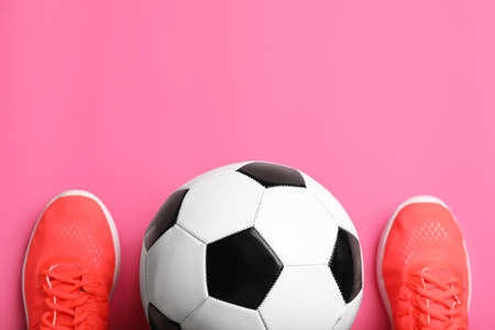 Soccer ball and shoes on color backgroundの写真素材
