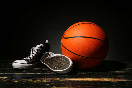 Ball for playing basketball and shoes on dark backgroundの写真素材