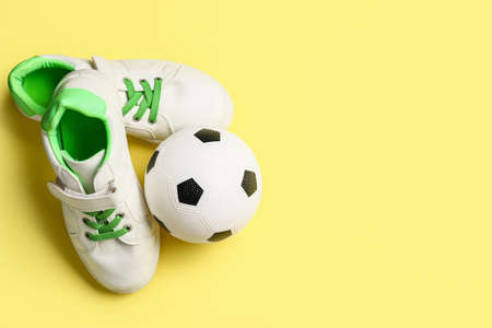 Soccer ball and shoes on color backgroundの写真素材