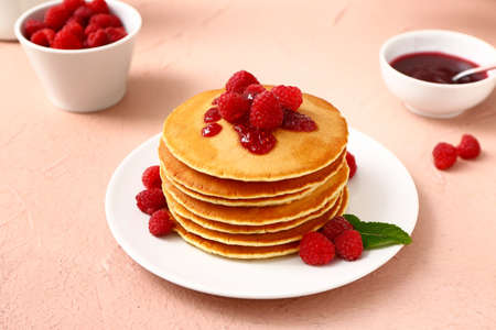 Sweet pancakes with berries on color background