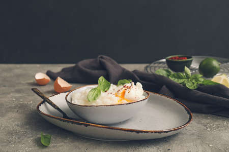 Bowl with boiled rice and egg on table