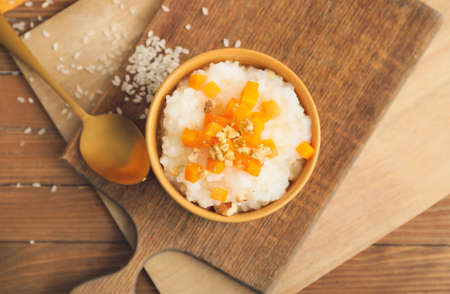 Bowl with boiled rice and pumpkin on tableの写真素材