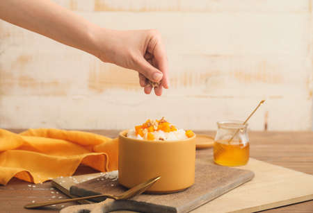 Woman preparing tasty rice on tableの写真素材
