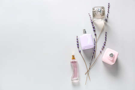 Bottles of different perfumes on light background