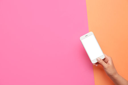 Woman holding mobile phone on color backgroundの写真素材