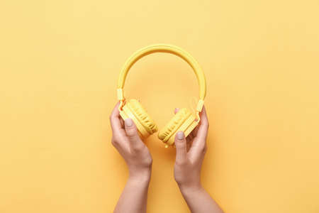 Woman with headphones on color backgroundの写真素材