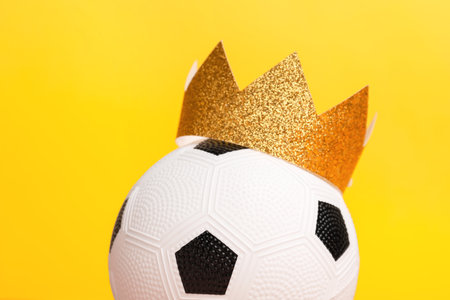 Soccer ball with paper crown on color backgroundの写真素材