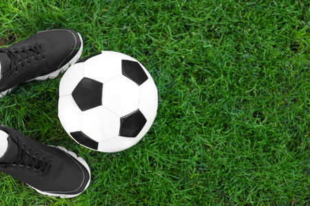 Football player with soccer ball on green grass outdoorsの写真素材