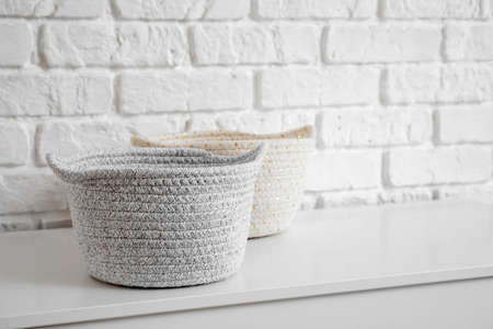 Wicker baskets on chest of drawers in room