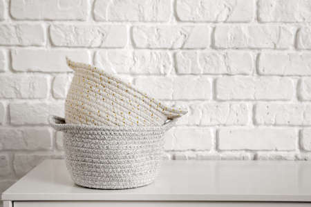 Wicker baskets on chest of drawers in roomの写真素材