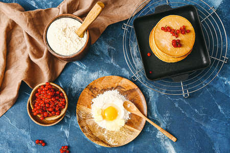 Tasty pancakes with ingredients on color backgroundの写真素材
