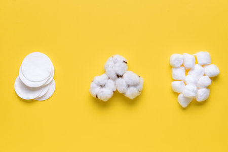 Cotton balls with pads and flowers on color backgroundの写真素材