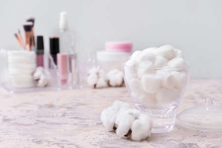 Cotton balls with cosmetics on table in bathroomの写真素材