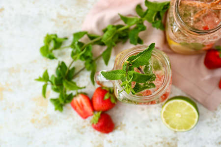 Mason jars of tasty strawberry mojito on light backgroundの写真素材