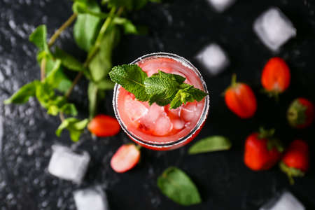 Glass of tasty strawberry cocktail on dark backgroundの写真素材