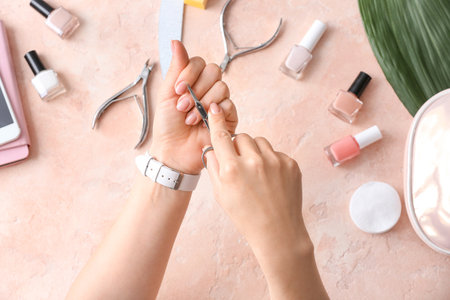 Woman doing manicure on color backgroundの写真素材