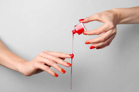 Hands with nail polish on gray backgroundの写真素材