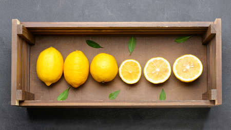 Wooden box with lemons on gray backgroundの写真素材