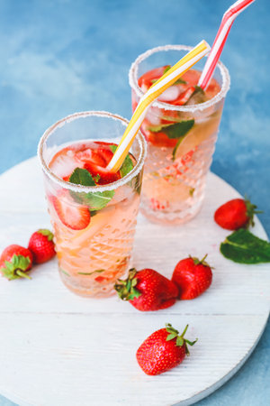 Glasses of tasty strawberry mojito on color backgroundの写真素材