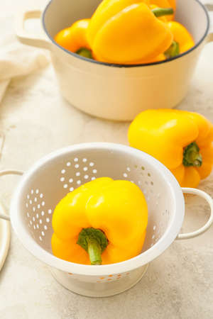 Yellow bell pepper in colander on tableの写真素材