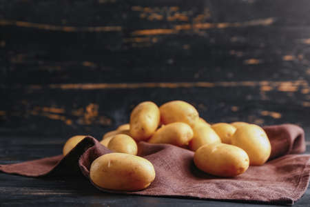 Raw potatoes on wooden tableの写真素材