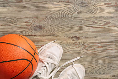 Ball for playing basketball game with shoes on wooden backgroundの写真素材