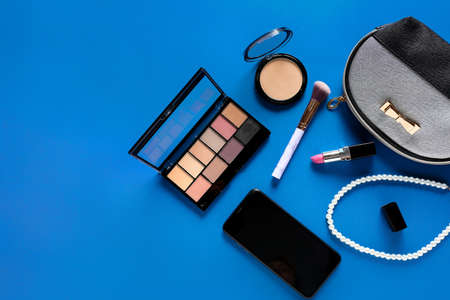 Composition with cosmetics, bag and mobile phone on color backgroundの写真素材