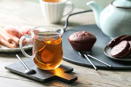 Cup of hot tea and sweets on tableの写真素材