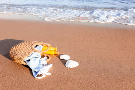 Bag with sunscreen cream on beachの写真素材