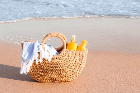 Bag with sunscreen cream on beachの写真素材