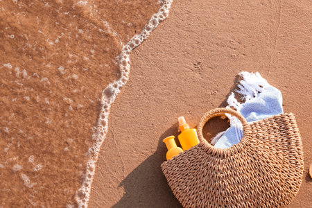 Bag with sunscreen cream on beachの写真素材