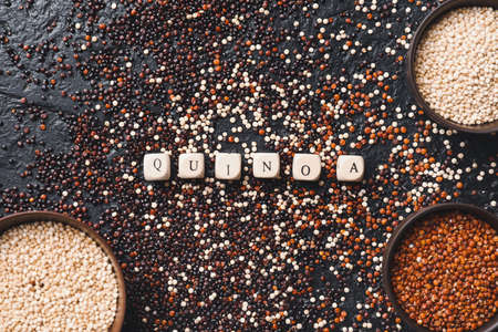 Bowls with different quinoa on dark background