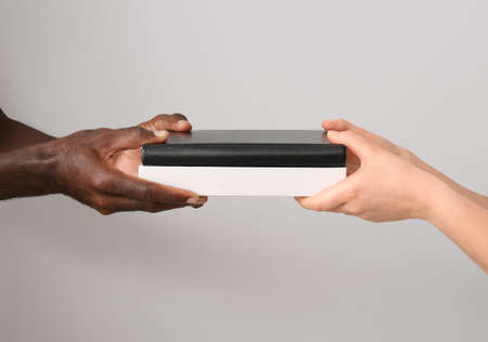 Hands of Caucasian woman and African-American man on gray background. Racism concept