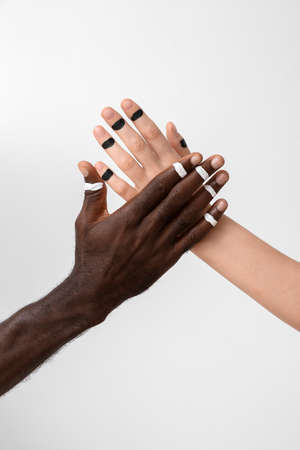 Hands of Caucasian woman and African-American man on light background. Racism conceptの写真素材