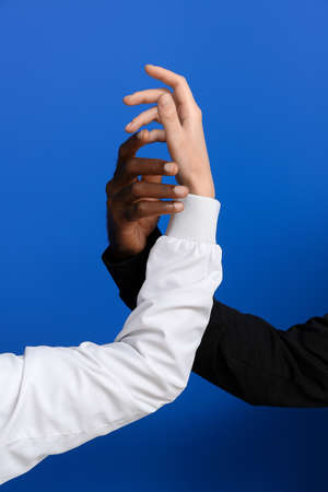 Hands of Caucasian woman and African-American man on color background. Racism conceptの写真素材