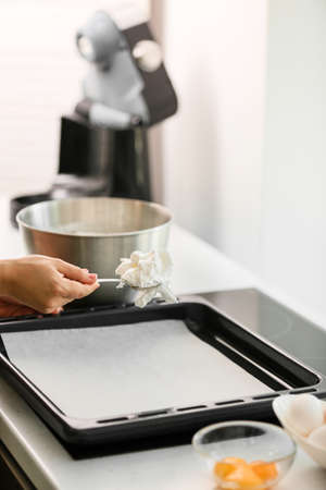 Woman preparing meringue for baking in kitchen