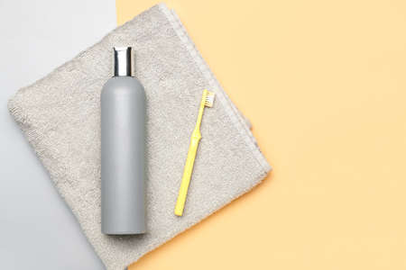 Shower gel and toothbrush on color background