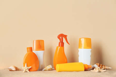 Bottles of sunscreen on color background