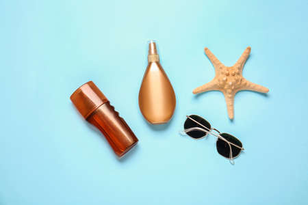 Bottles of sunscreen with sunglasses on color backgroundの写真素材