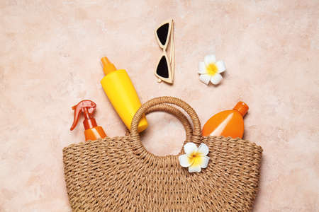 Beach accessories with sunscreen cream on color background