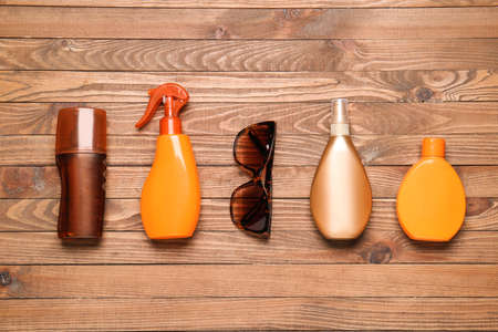 Bottles of sunscreen with sunglasses on wooden backgroundの写真素材