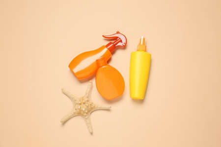Bottles of sunscreen on color background