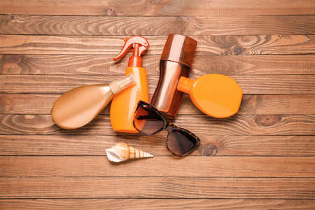 Bottles of sunscreen with sunglasses on wooden backgroundの写真素材