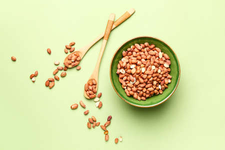 Raw peanuts on color background