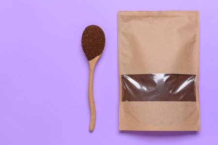 Bag and spoon with coffee powder on color backgroundの写真素材